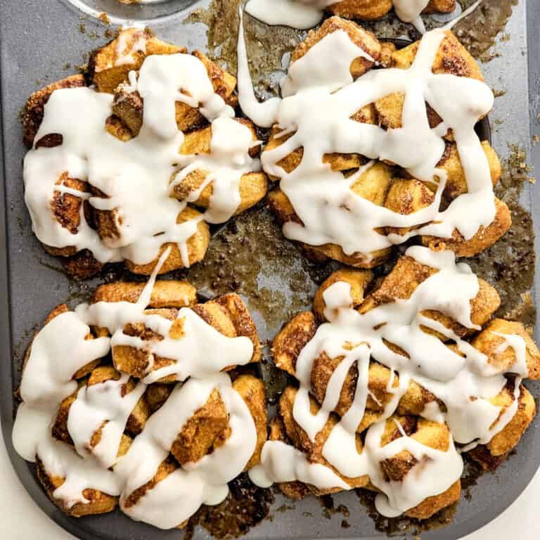 monkey bread muffins in muffin tin with frosting on top