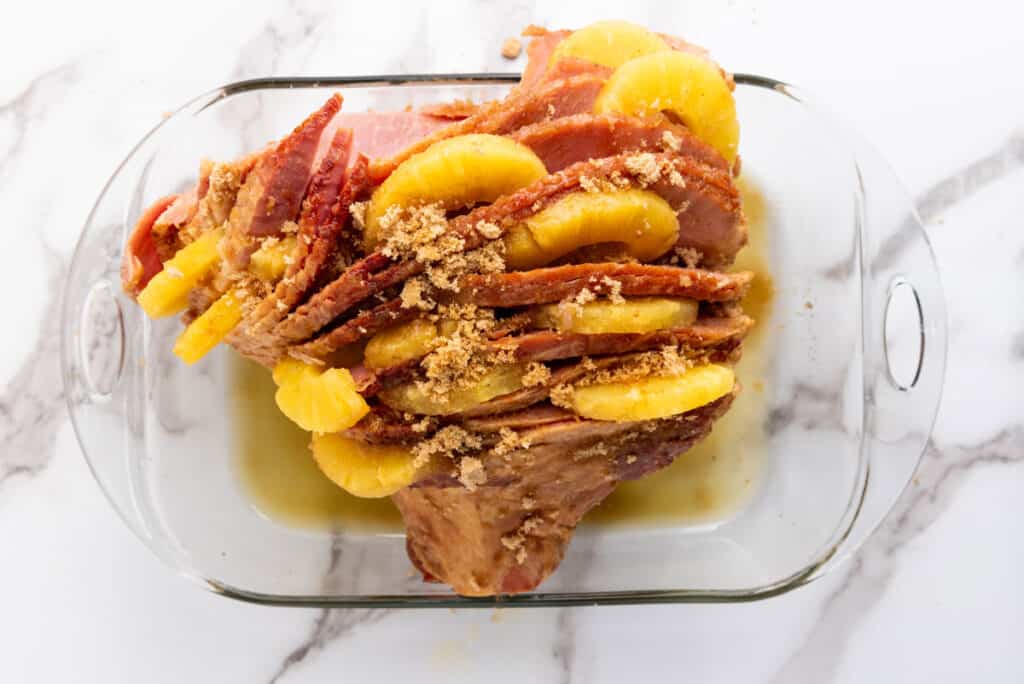 ham with pineapple between slices and sprinkled with brown sugar