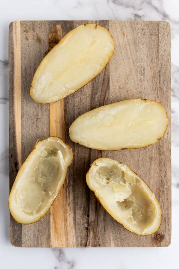 scooping out potato for twice baked potatoes