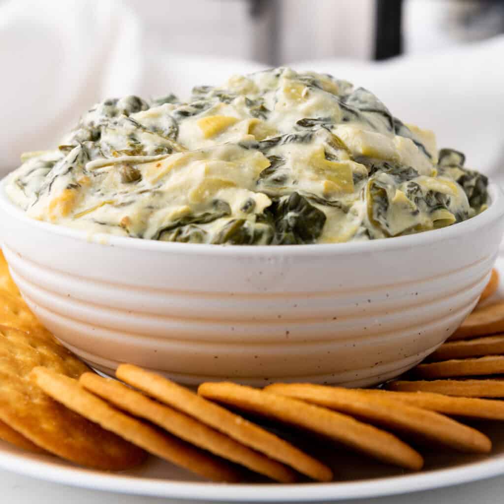 close up of Slow Cooker Spinach Artichoke Dip and crackers