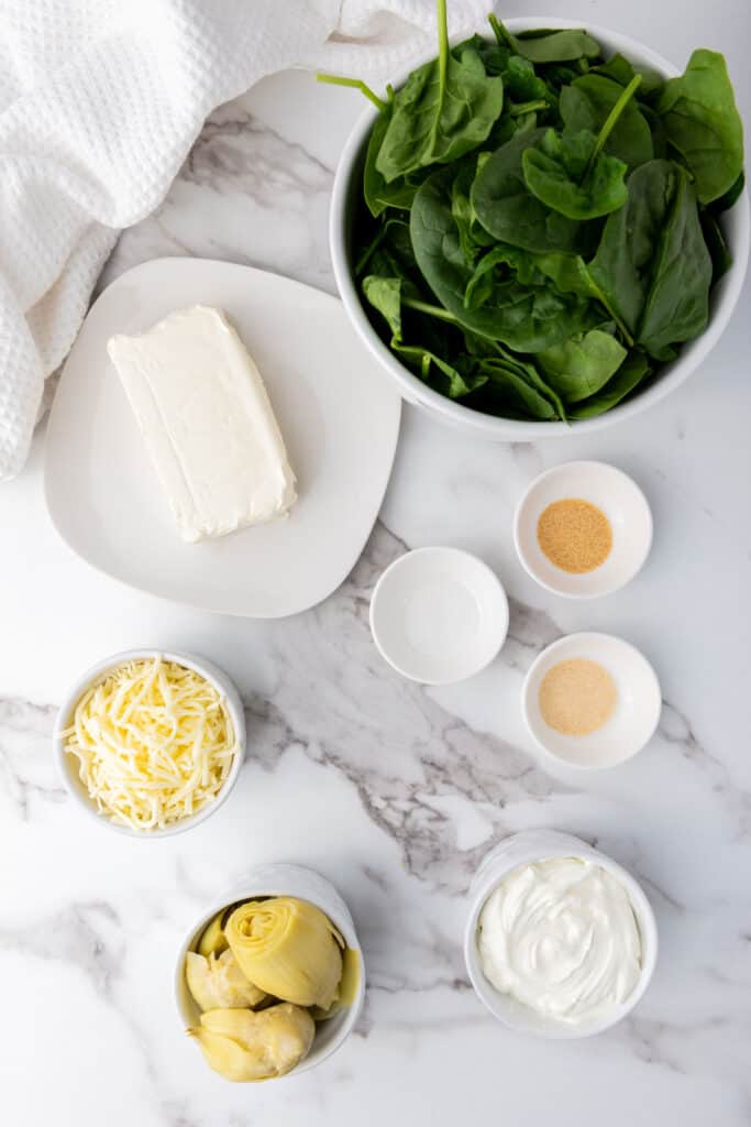 Slow Cooker Spinach Artichoke Dip ingredients on marble counter