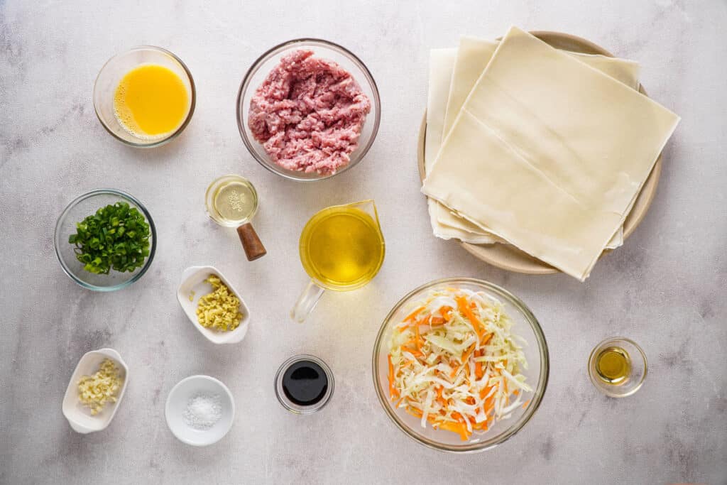 egg roll ingredients in glass bowls on countertop