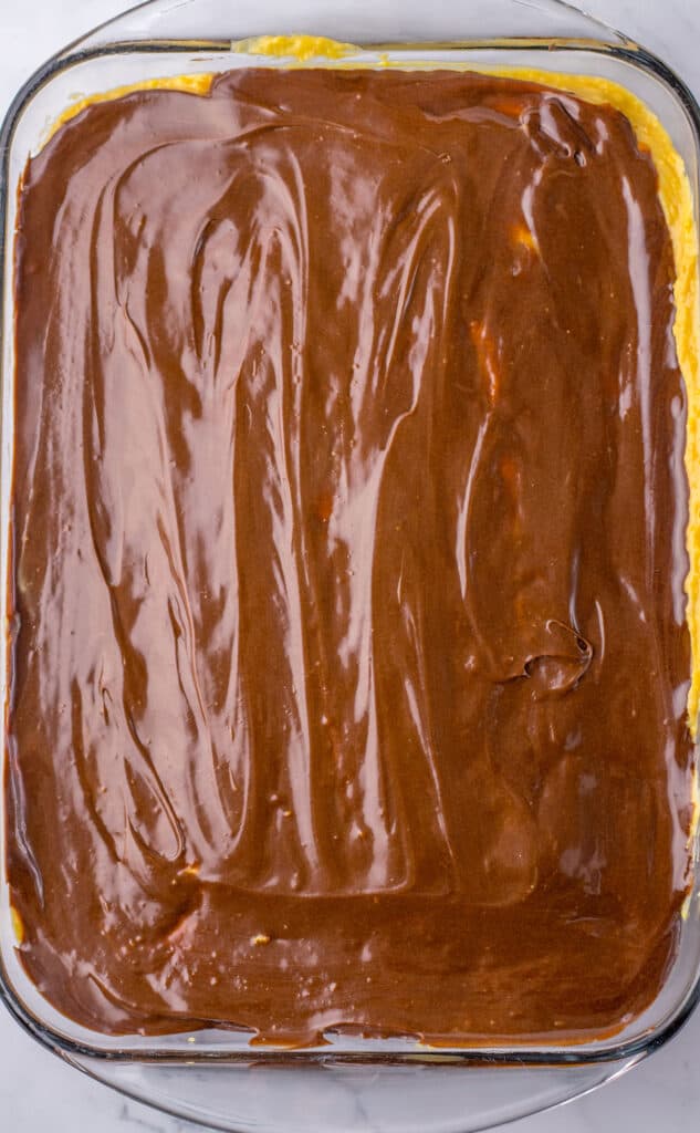 spreading chocolate on peanut butter poke cake