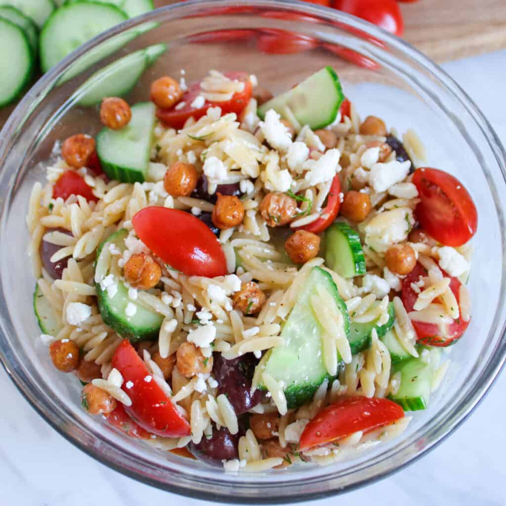 Greek orzo salad in glass bowl