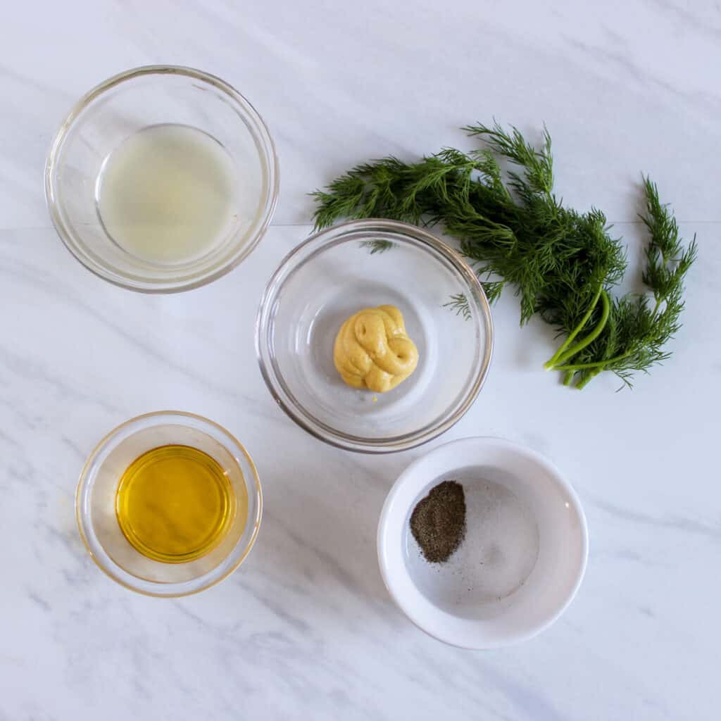 Greek orzo salad dressing ingredients on countertop in bowls