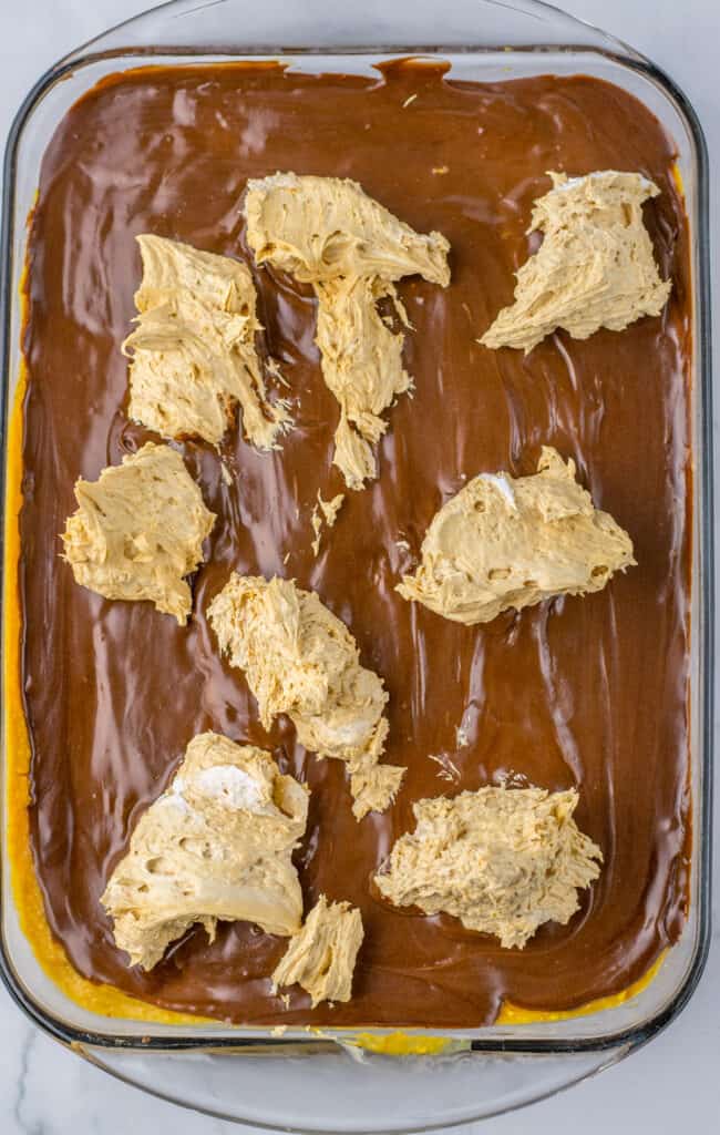 spreading topping on peanut butter poke cake