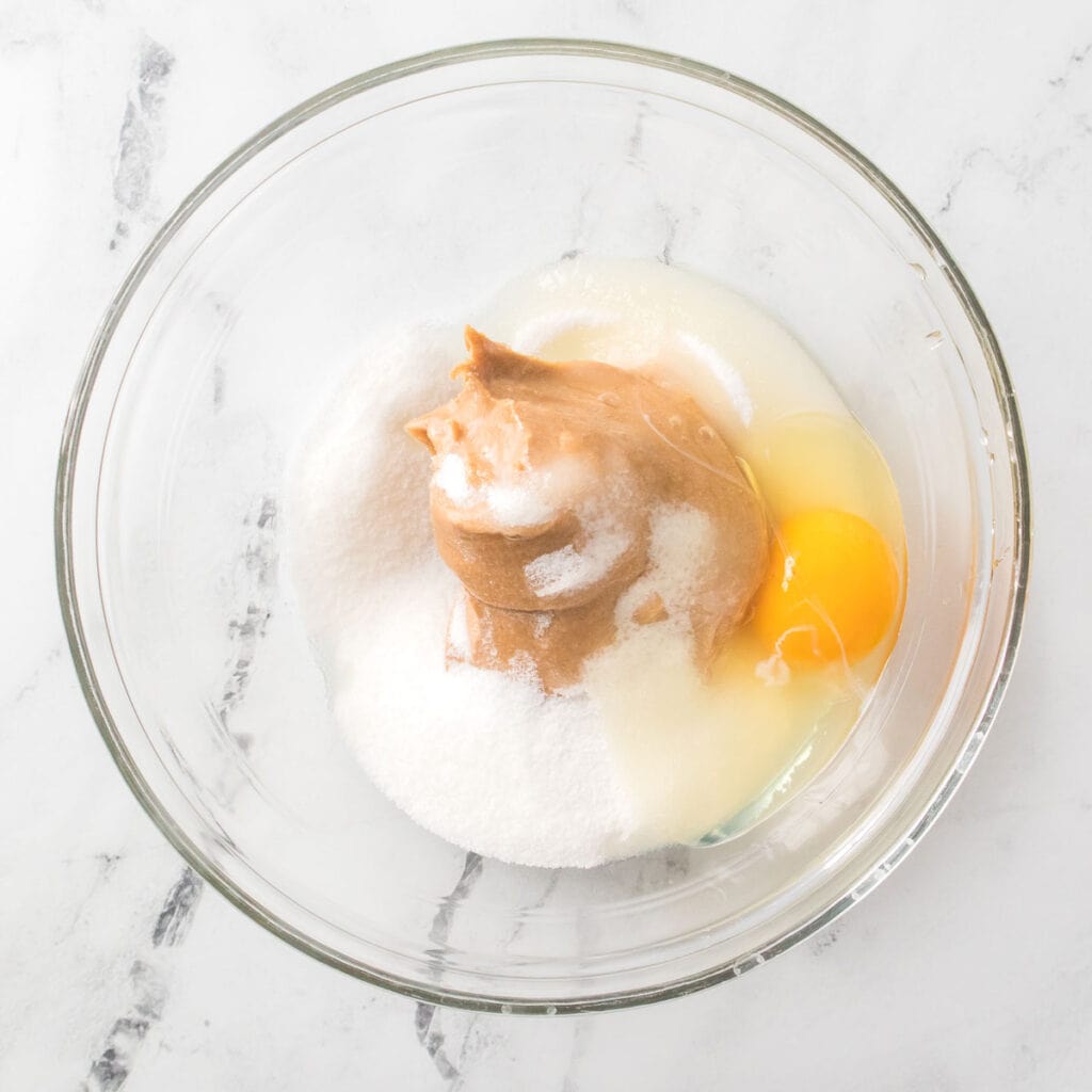 egg, sugar, and peanut butter in glass bowl