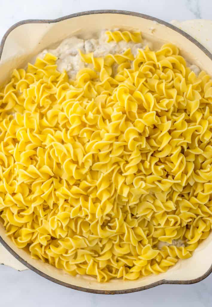 adding noodles to make french onion and beef casserole