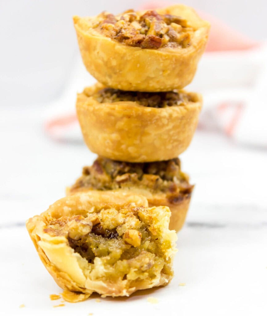 stack of mini pecan tarts with one with bite removed