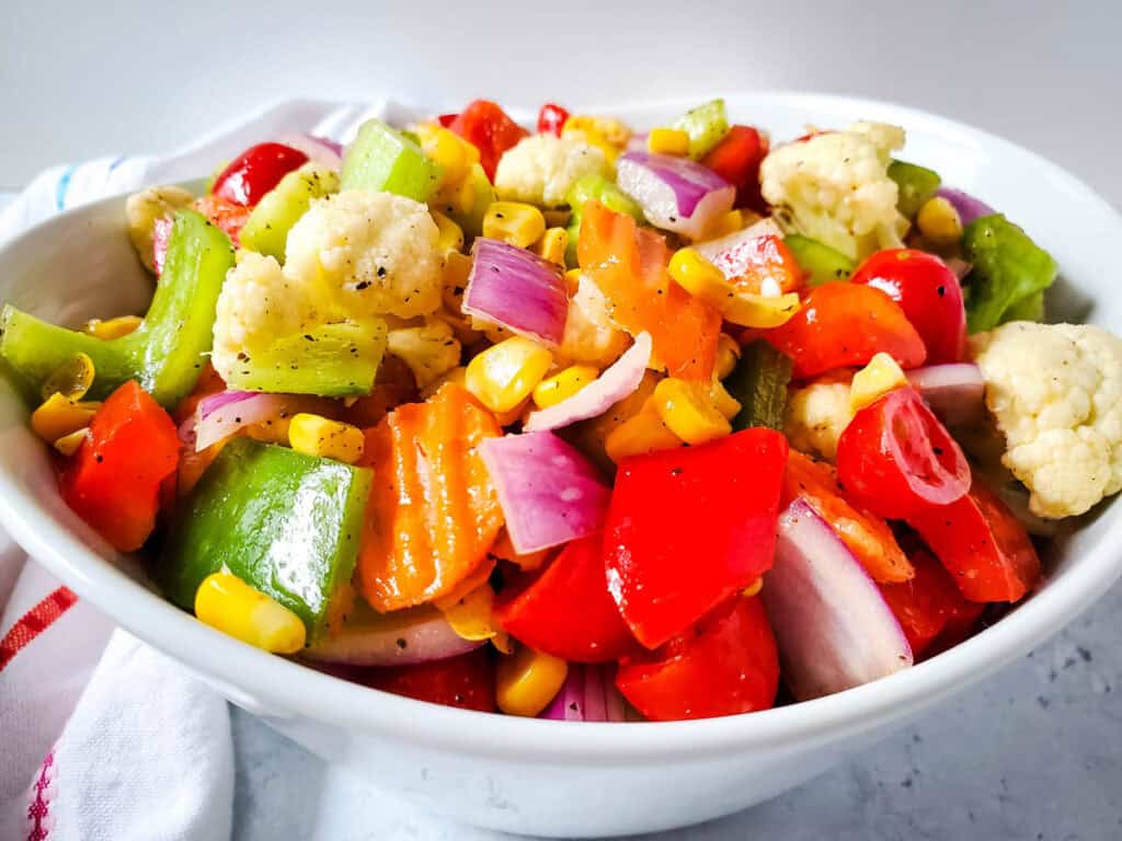 colorful rainbow vegetable salad in white bowl