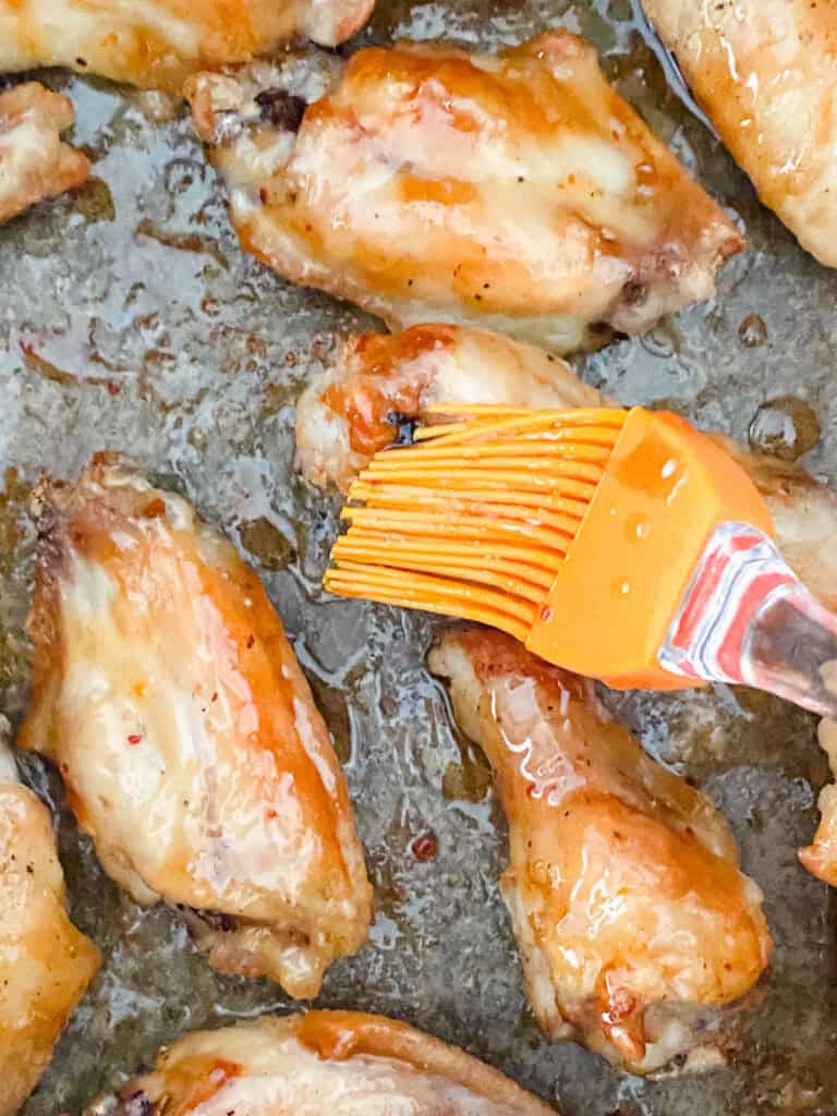 brushing sauce on sweet chili wings