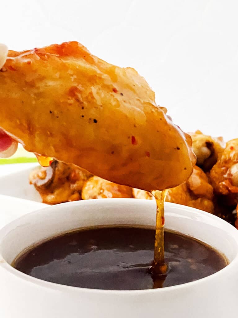dipping sweet chili wings in sauce