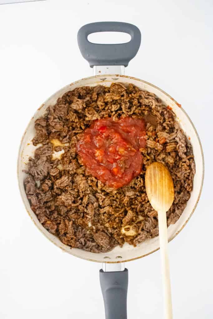 adding salsa to taco meat in pan