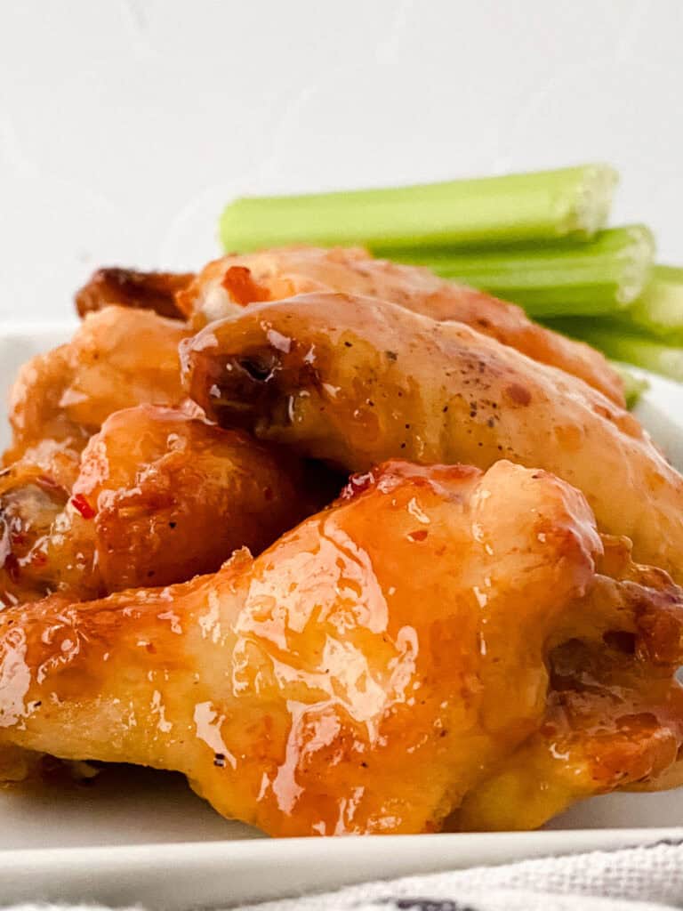 sweet chili wings and celery on white plate