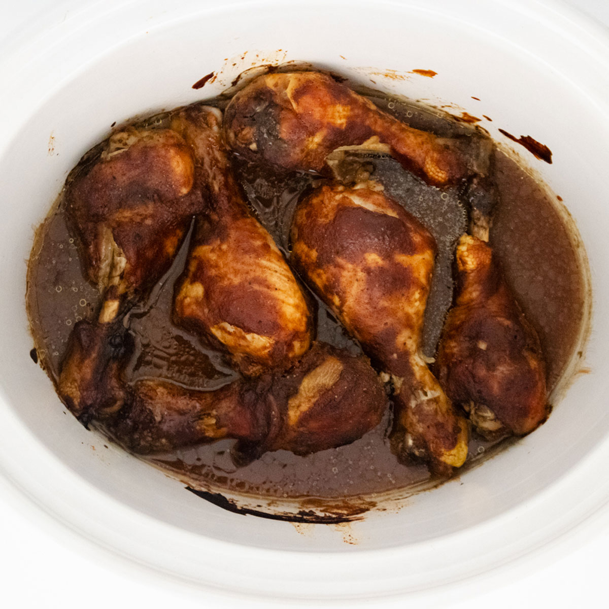 slow cooker barbecue drumsticks in crock pot with sauce