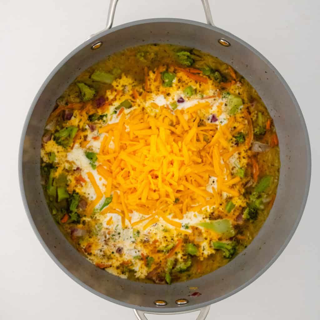 making broccoli cheddar orzo in skillet