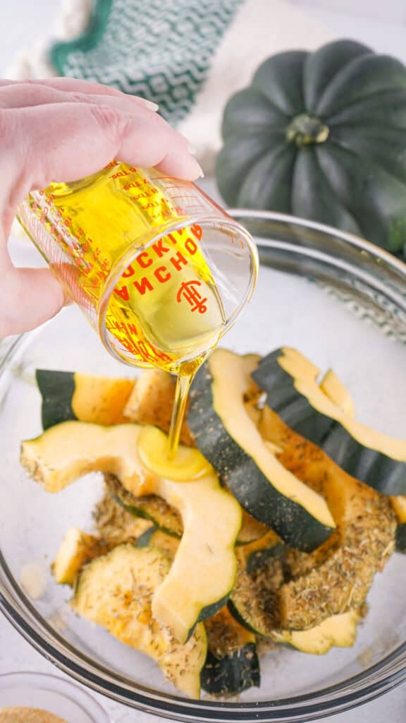pouring oil on acorn squash