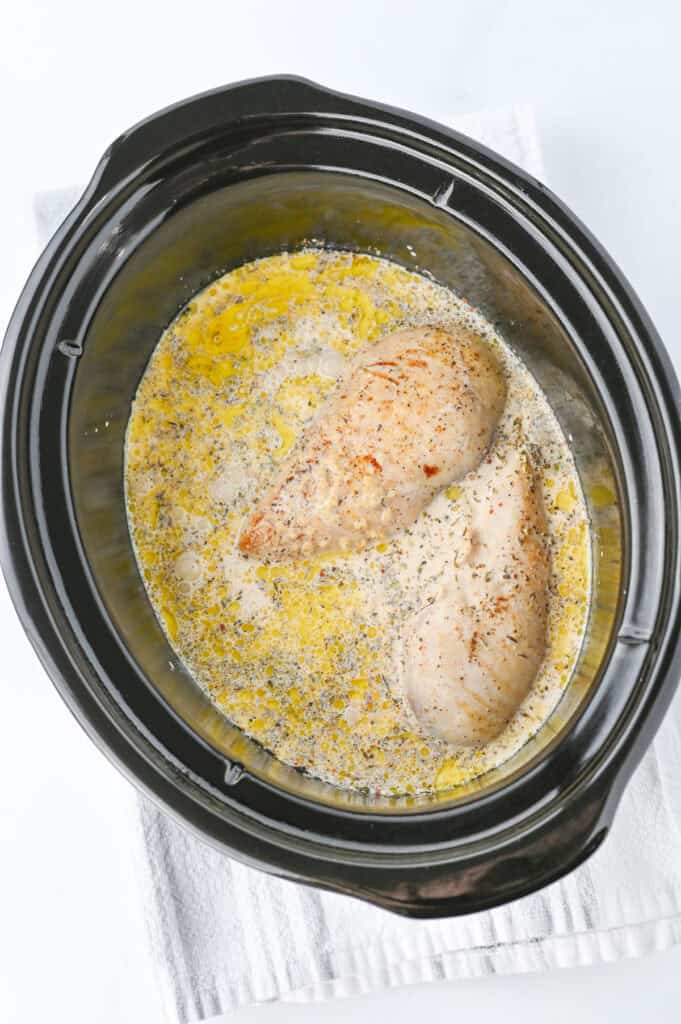 adding chicken to slow cooker with sauce for Slow cooker marry me chicken