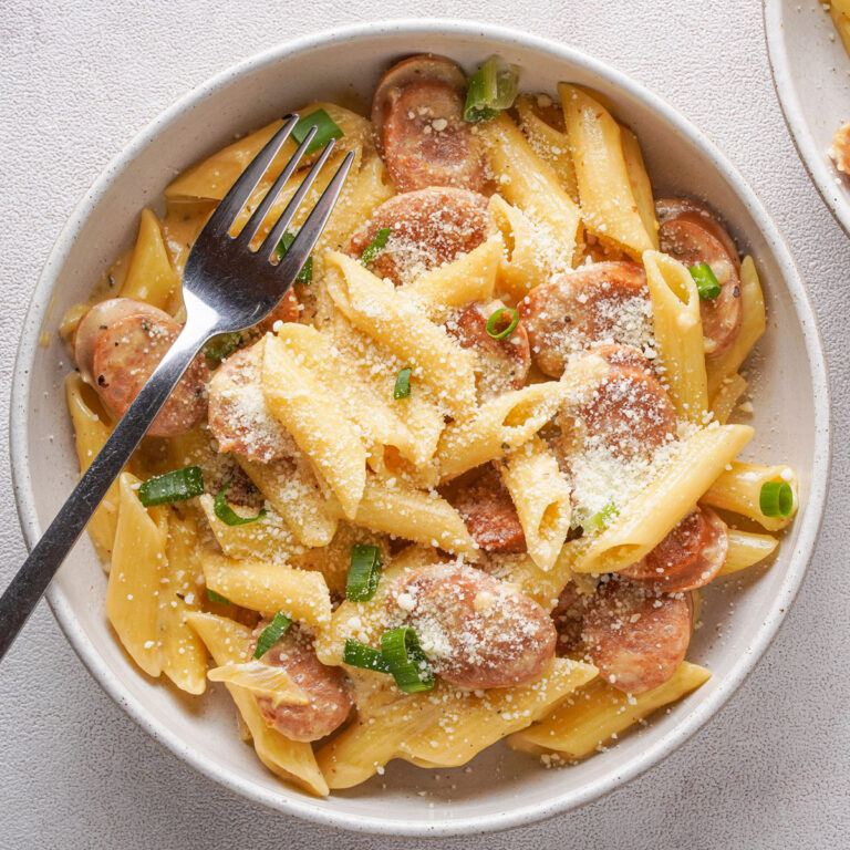 Cheesy Kielbasa Pasta in white bowl with fork