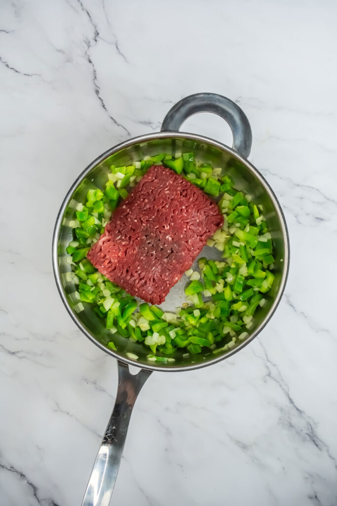 ground beef and green onions in pan