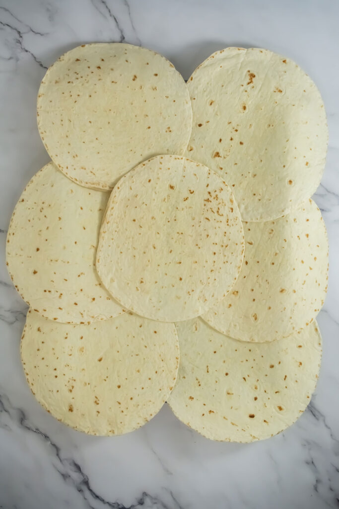 tortillas layered on baking sheet