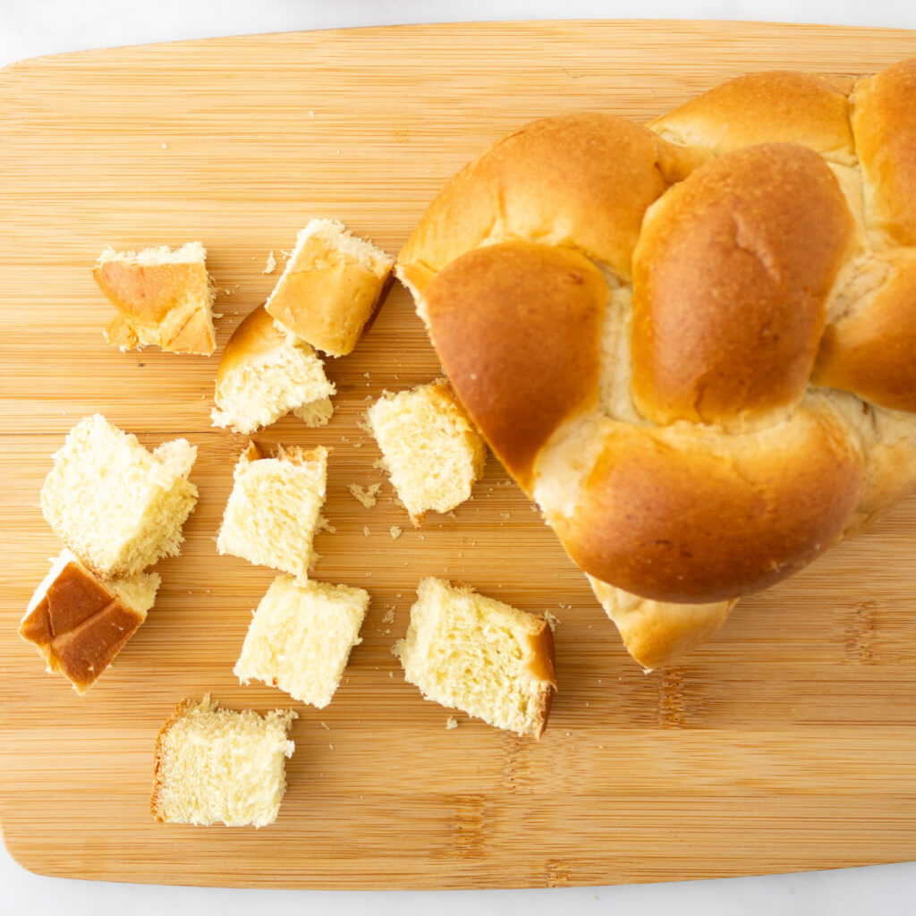 challah bread cut into cubes on cutting board