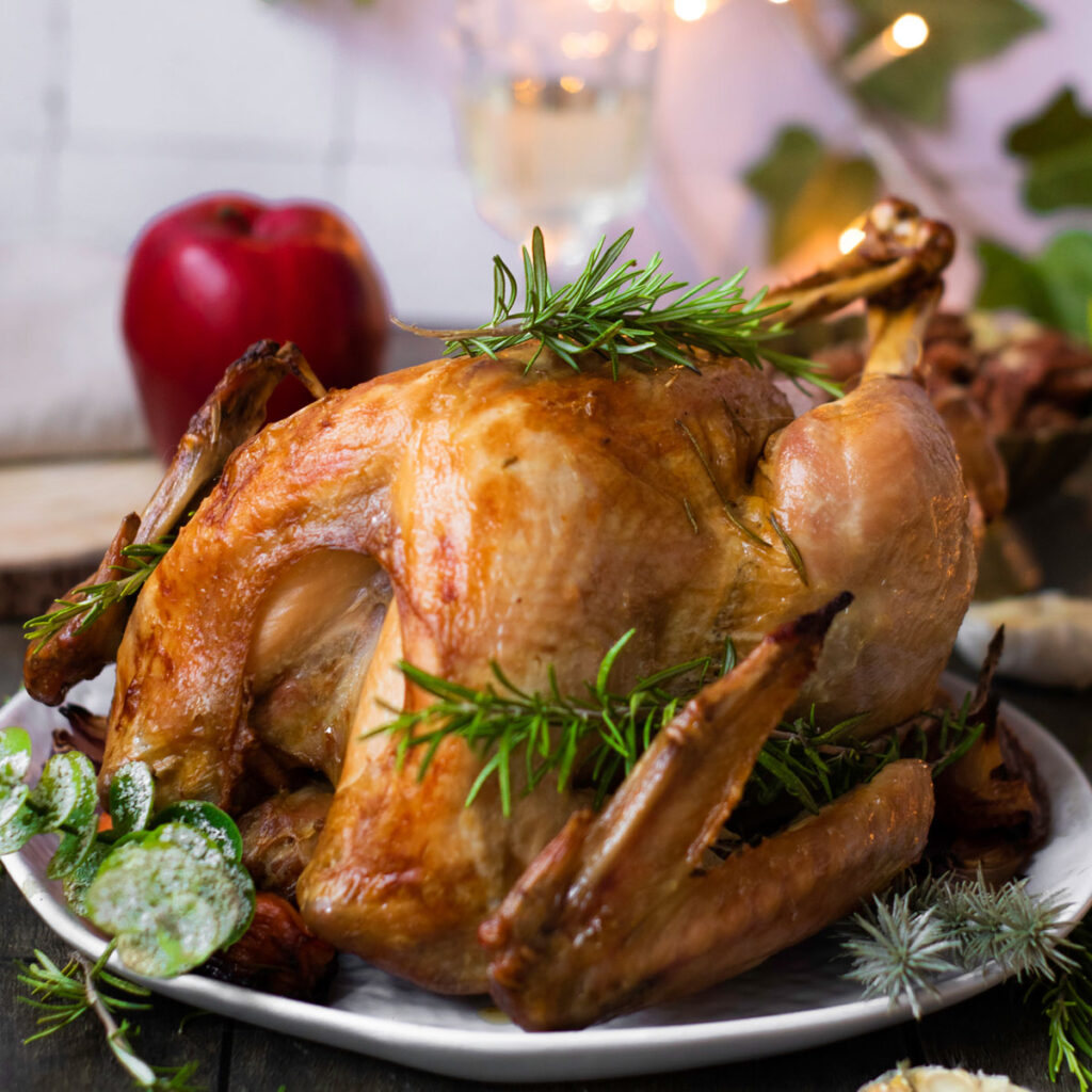 Thanksgiving turkey on platter with fresh herb garnish