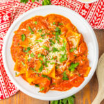 white bowl with spicy lasagna soup and red patterned napkin