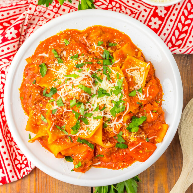 white bowl with spicy lasagna soup and red patterned napkin