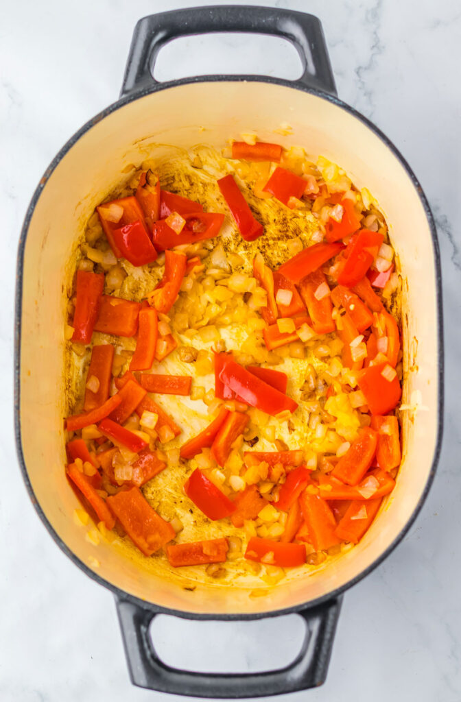 onions and sliced red peppers in pot