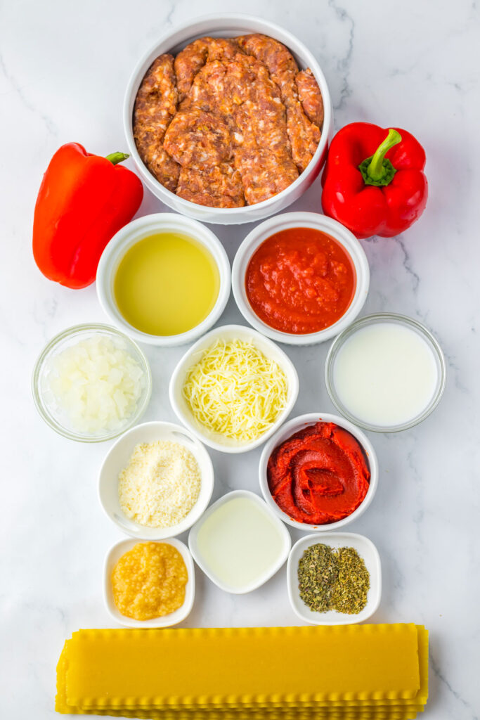 ingredients for lasagna soup in bowls on marble counter