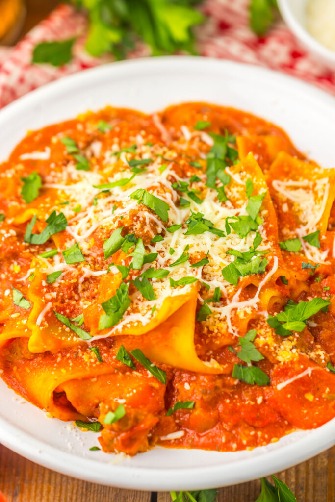 close up of lasagna soup in white bowl