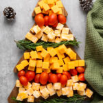 easy Christmas tree cheese platter with green napkin and pine cones
