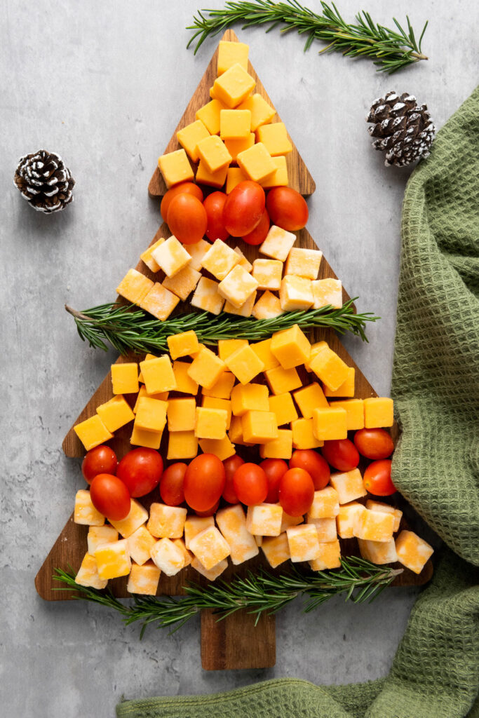 easy Christmas tree cheese platter with green napkin and pine cones
