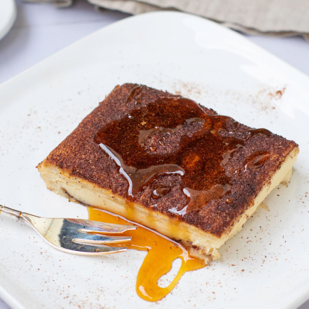 piece of churro cheesecake bars  with maple syrup