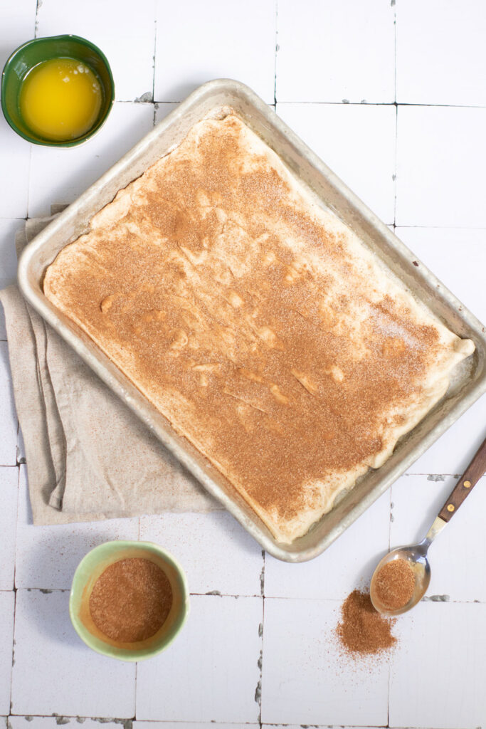 crescent roll dough in pan with cinnamon sugar