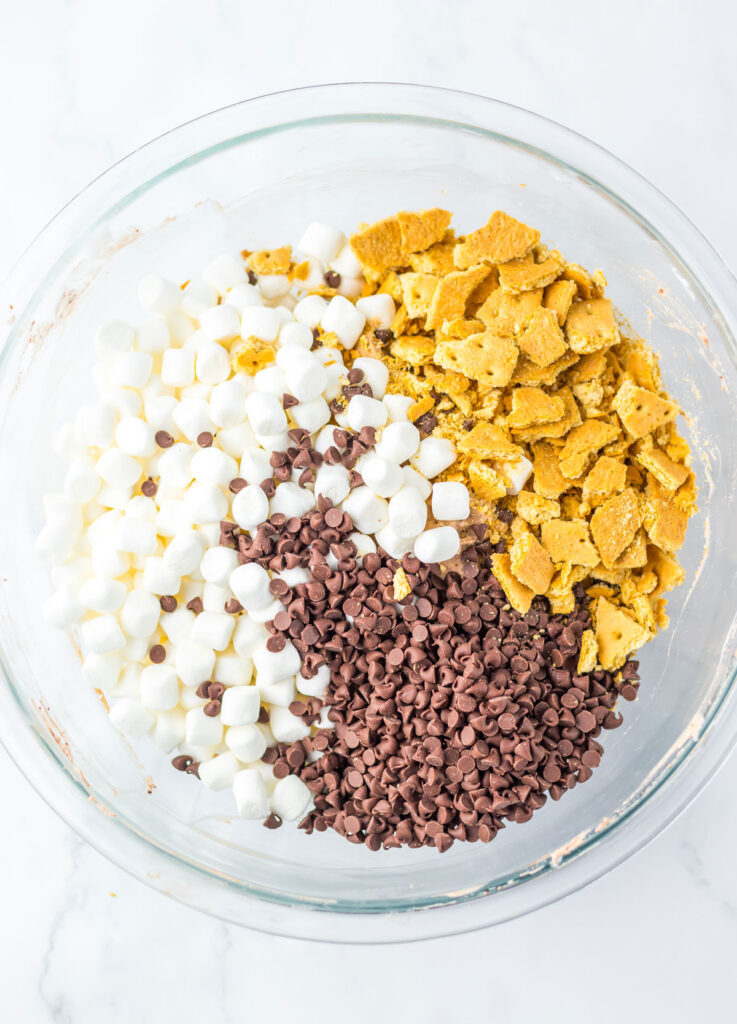 chocolate chips, marshmallows, and crumbled graham crackers in glass bowl