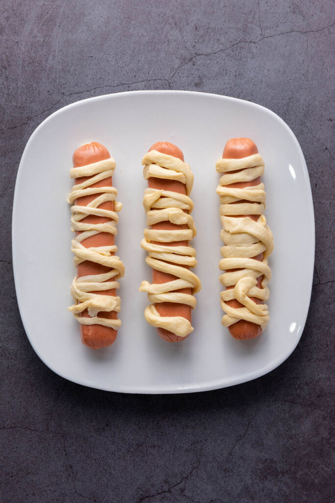 hot dogs wrapped with strips of crescent roll dough