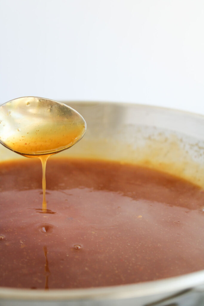 spoon dripping orange chicken sauce