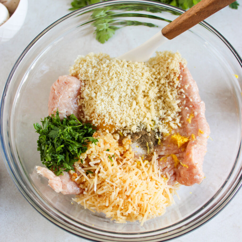 ingredients for chicken meatballs in glass bowl before mixing