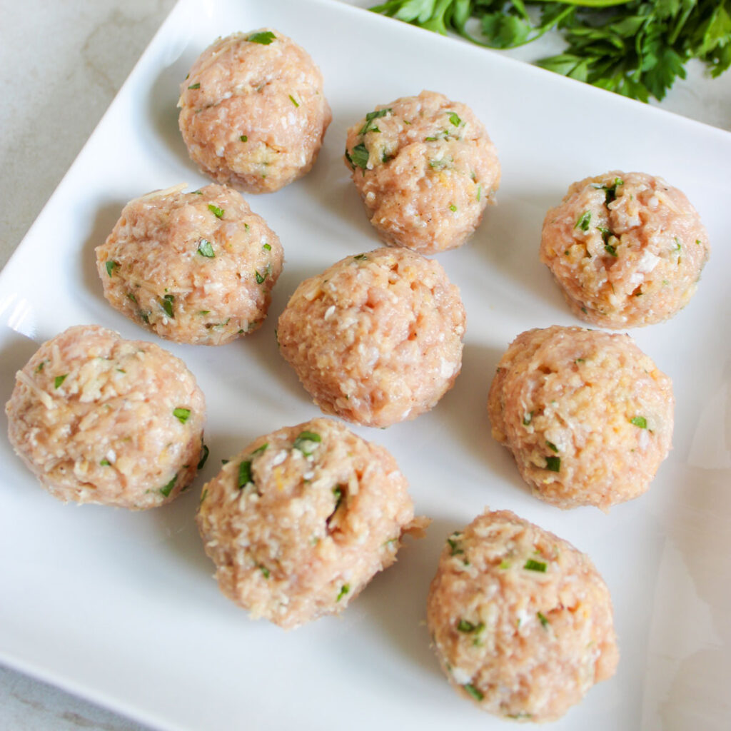 raw chicken meatballs on white plate