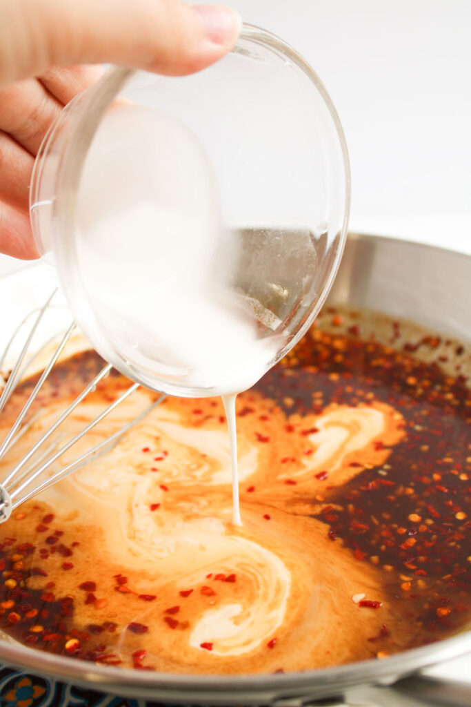 pouring slurry into sauce for general tsos chicken