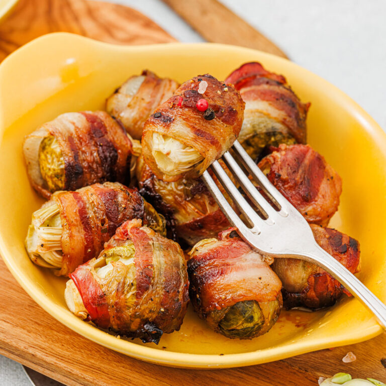 bacon wrapped brussel sprouts on yellow plate with fork