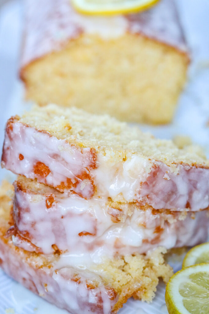 three slices of lemon loaf cake with remaining cake in background