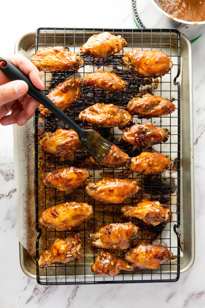 brushing sauce on asian sticky wings
