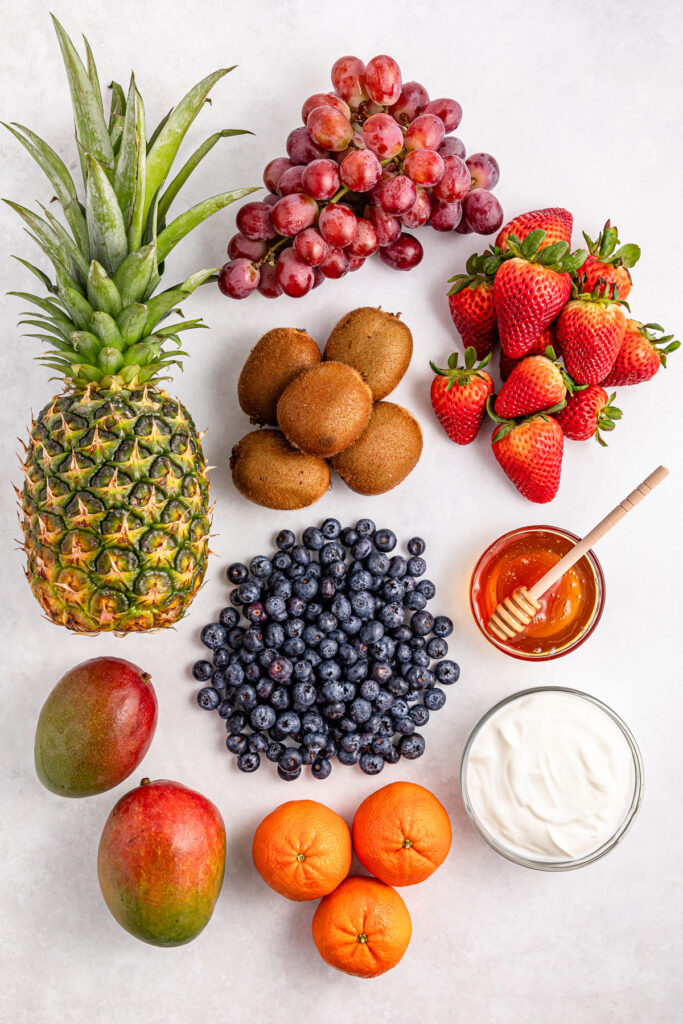 fresh fruit, honey, and Greek yogurt on countertop for fruit salad