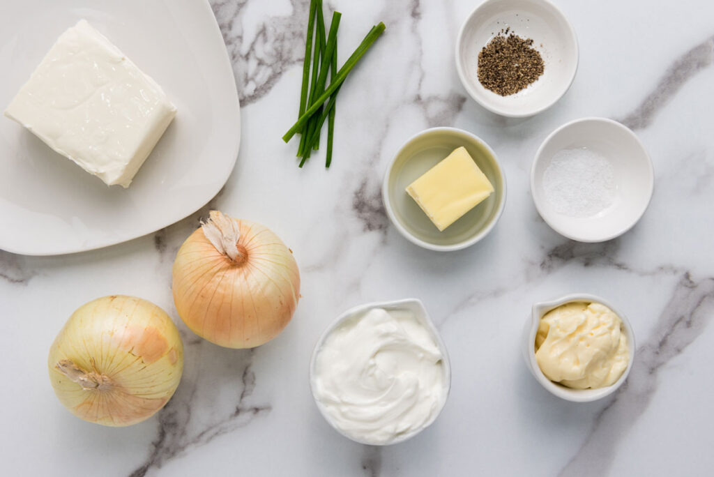 caramelized onion dip ingredients in bowls on marble countertop