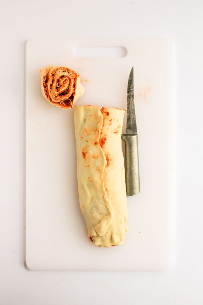 cutting pizza pinwheels on cutting board
