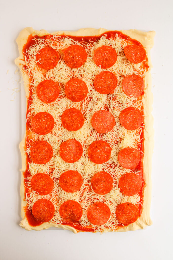 dough with marinara, mozzarella cheese, and pepperonis