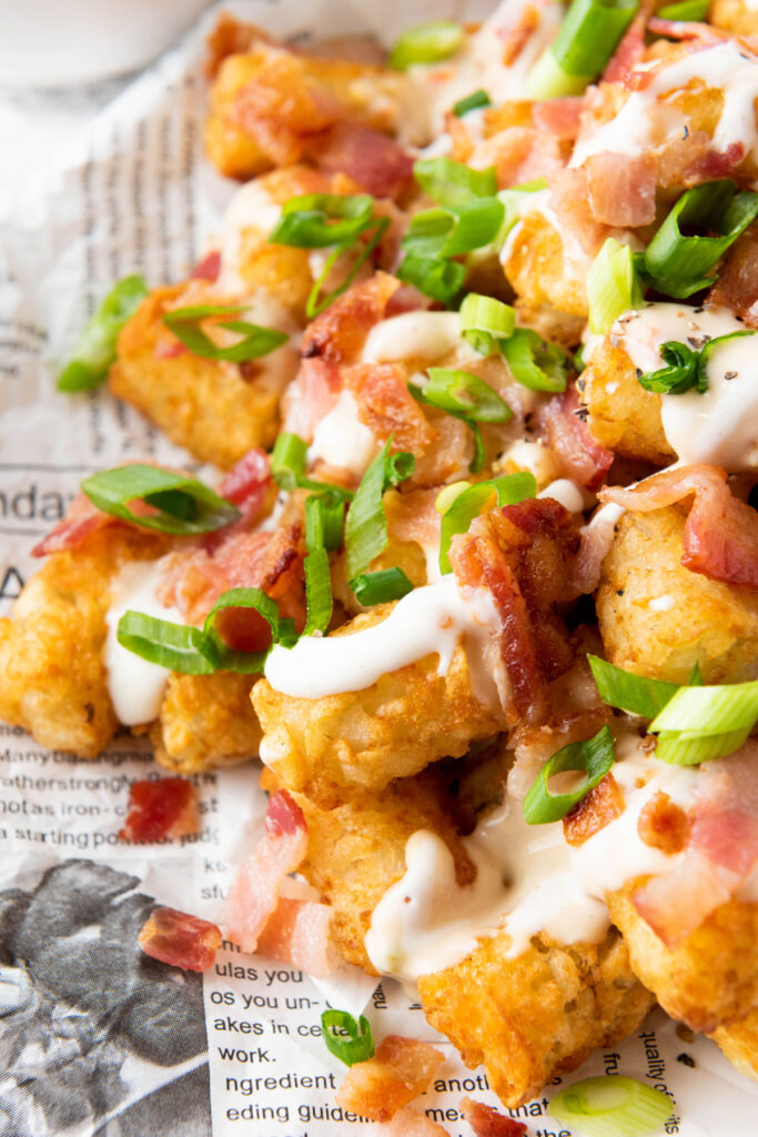 close up of loaded tater tots with bacon and green onion